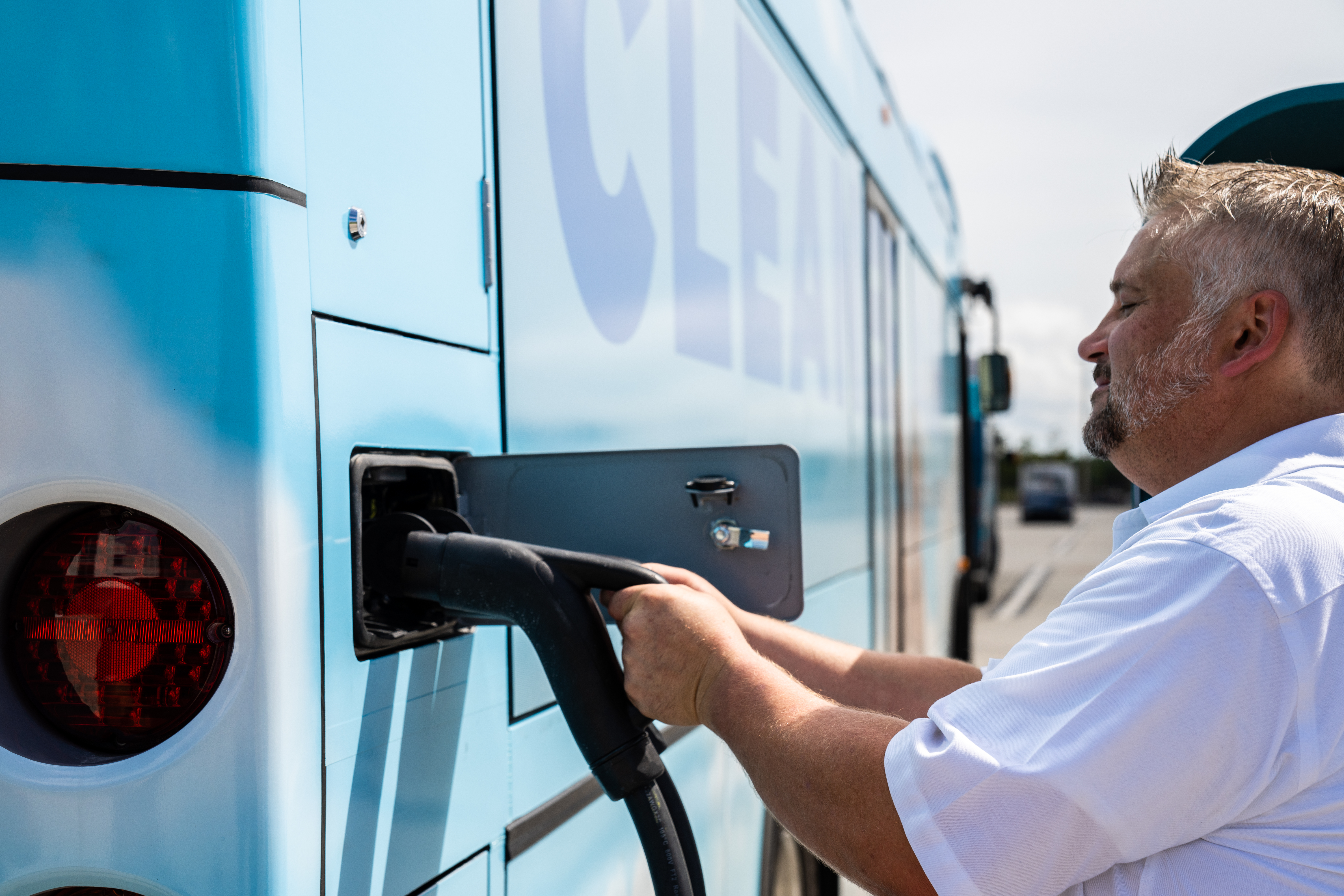 bus technician charging an electric city bus