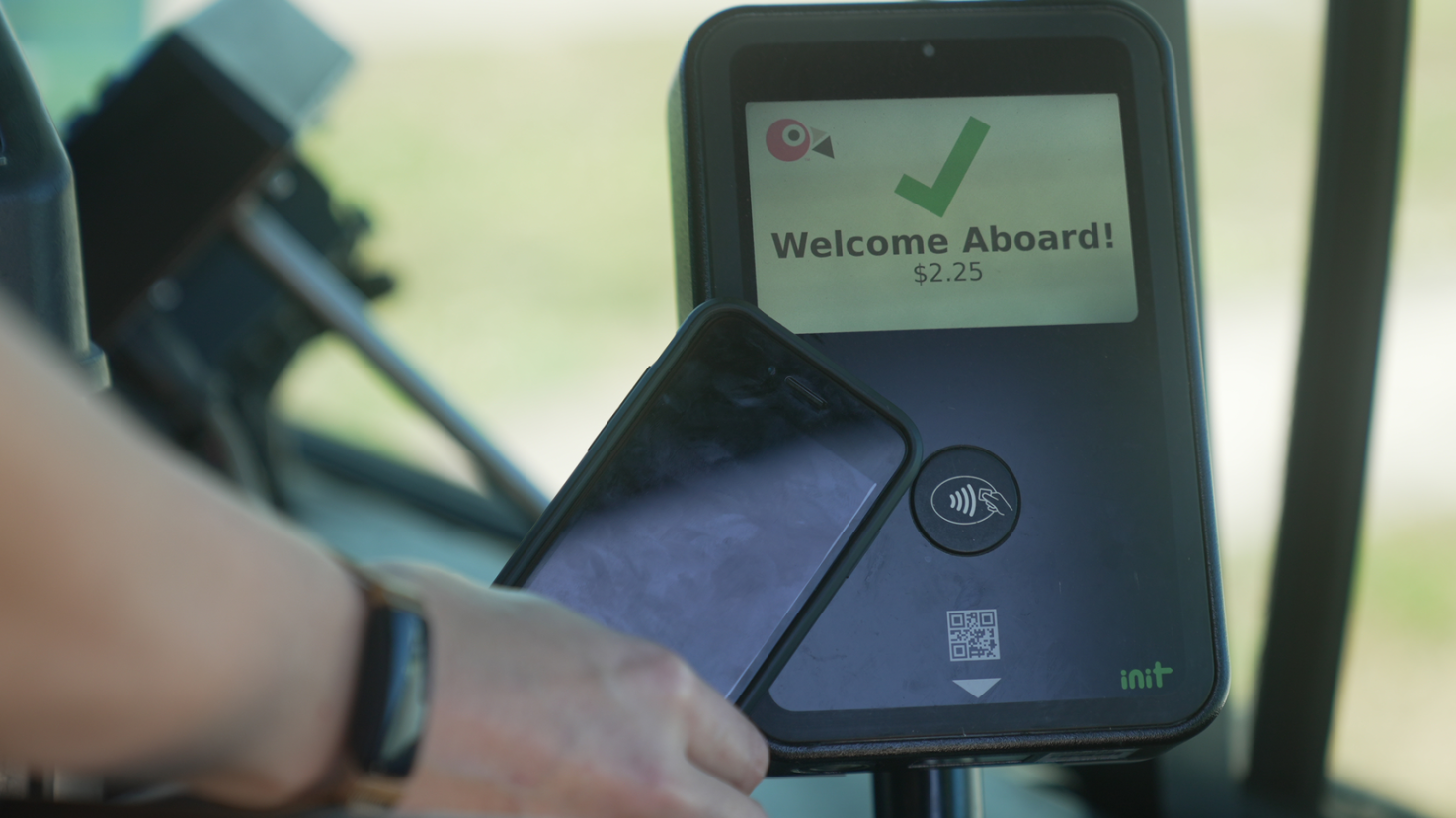 Someone paying their fare with a tap-enabled smartphone