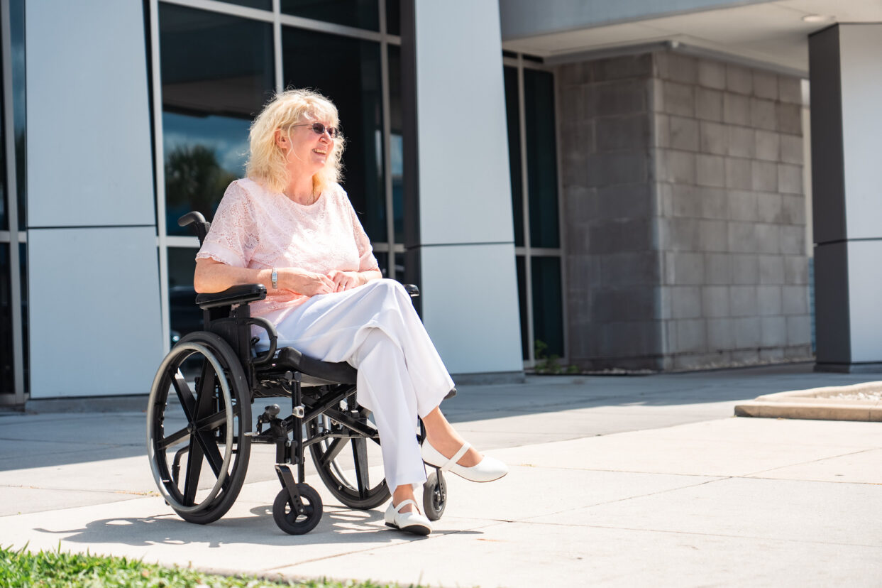 A woman in a wheelchair waiting for a bus