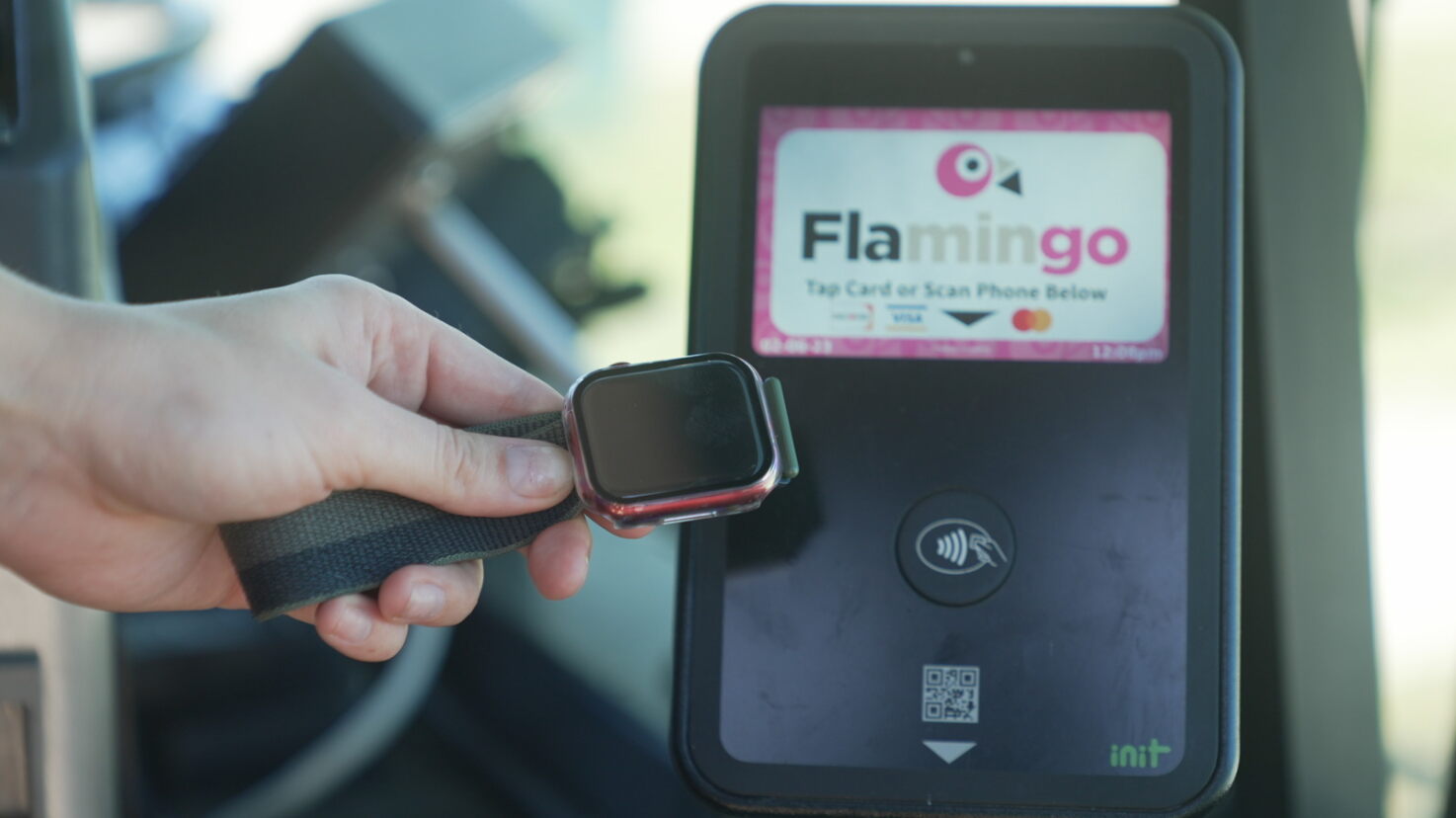 Someone paying their bus fare with a tap-enabled smartwatch
