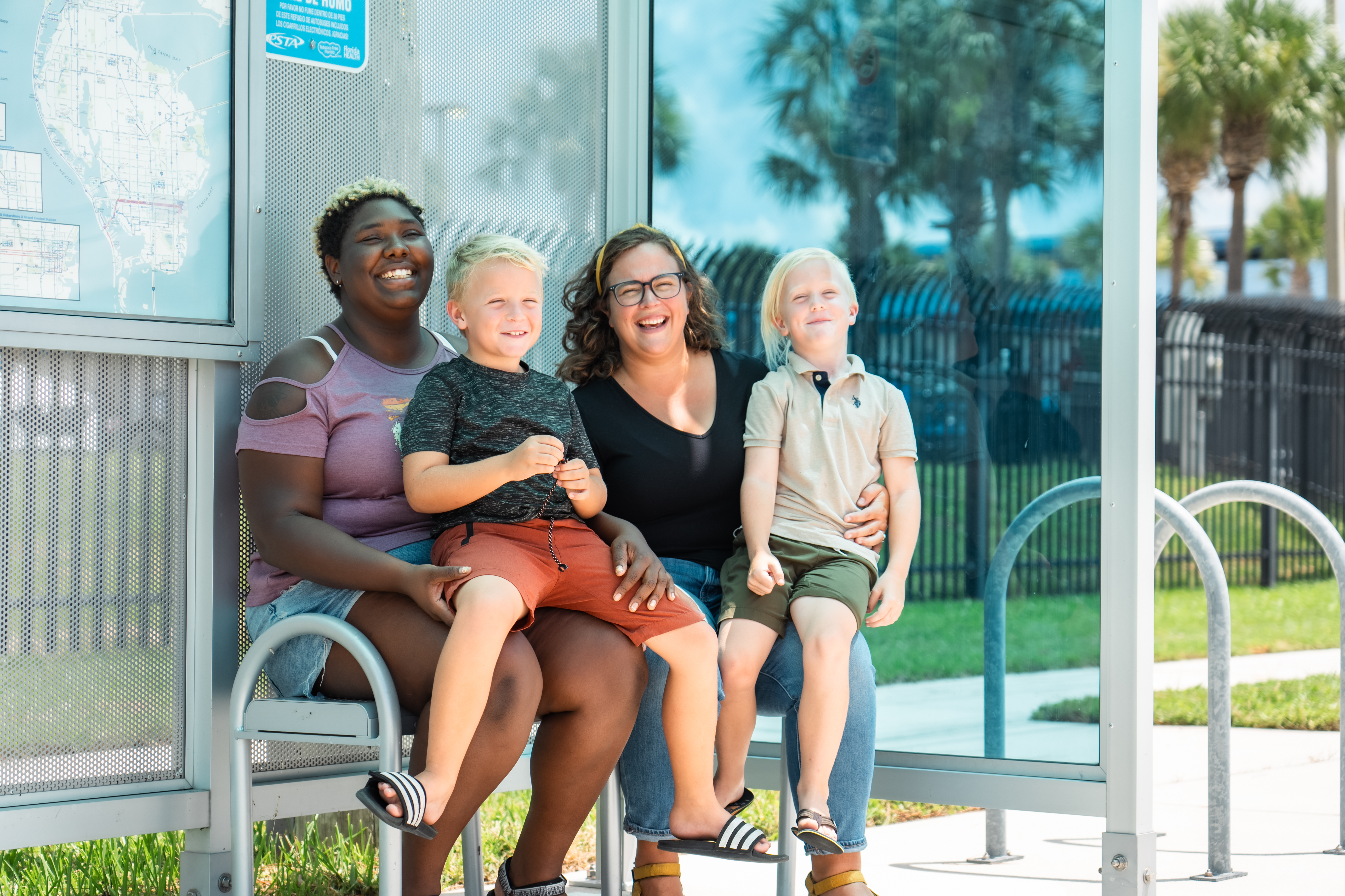 Picture of a diverse family waiting at a PSTA bus shelter