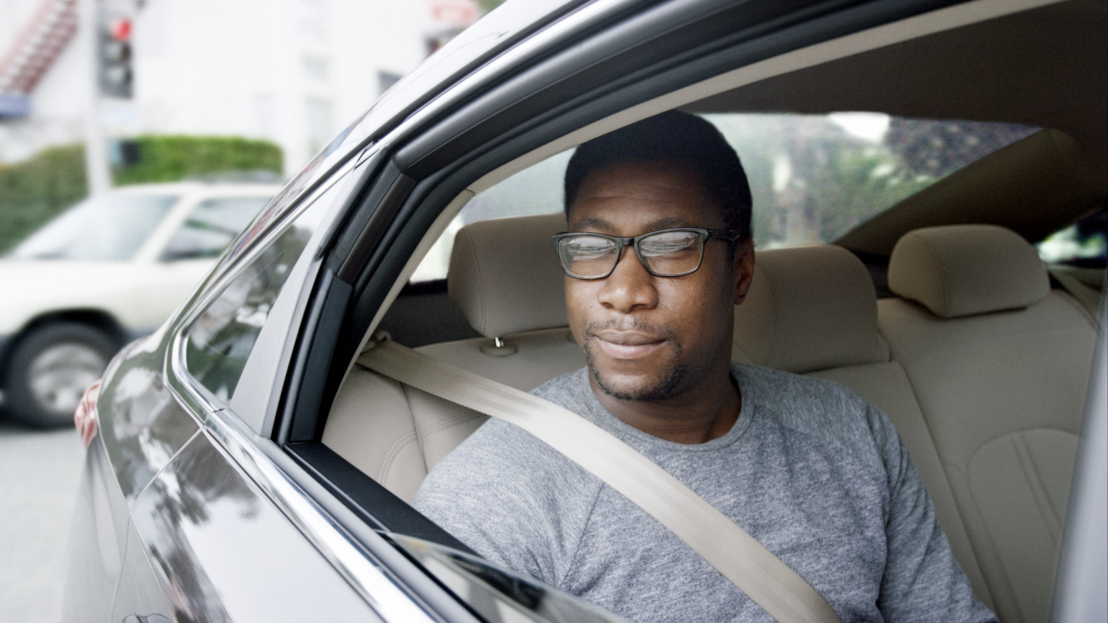 An Uber or Lyft passenger sitting in the backseat of a car.