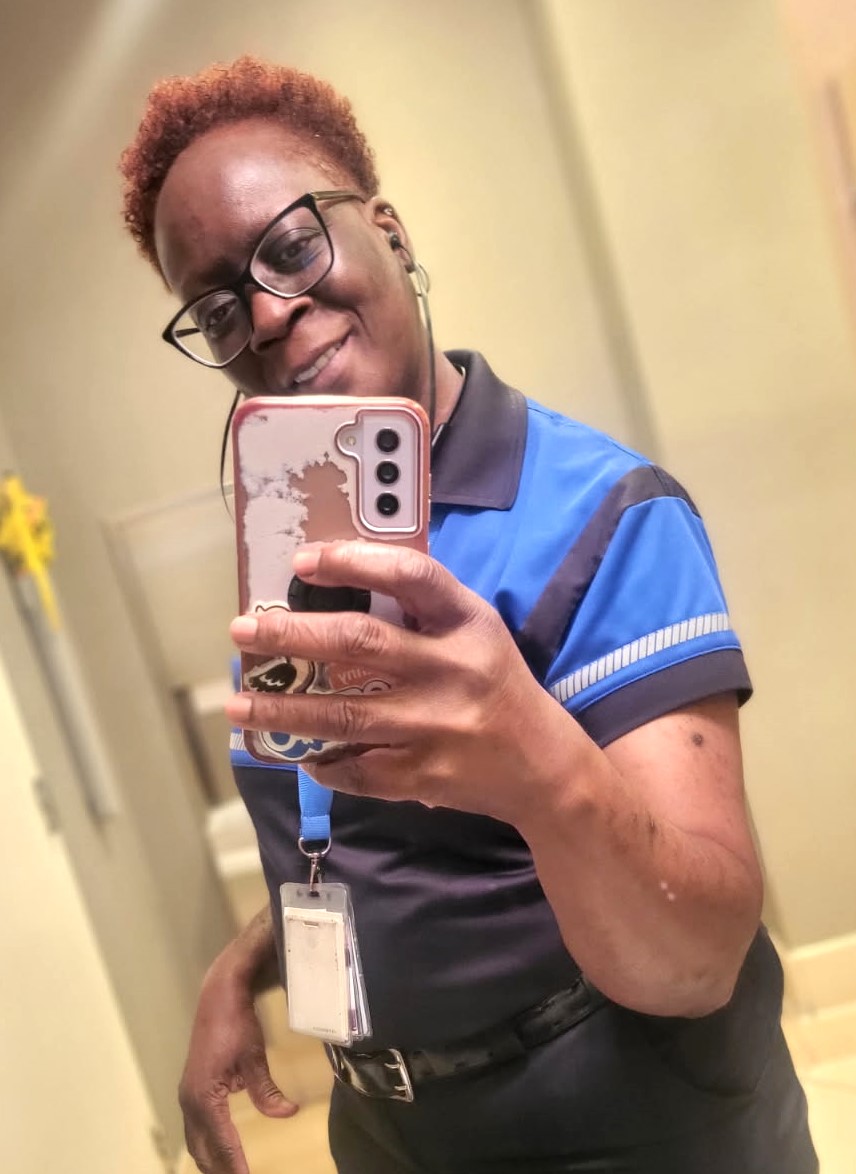 A mirror selfie of Liz wearing a black and blue PSTA shirt.
