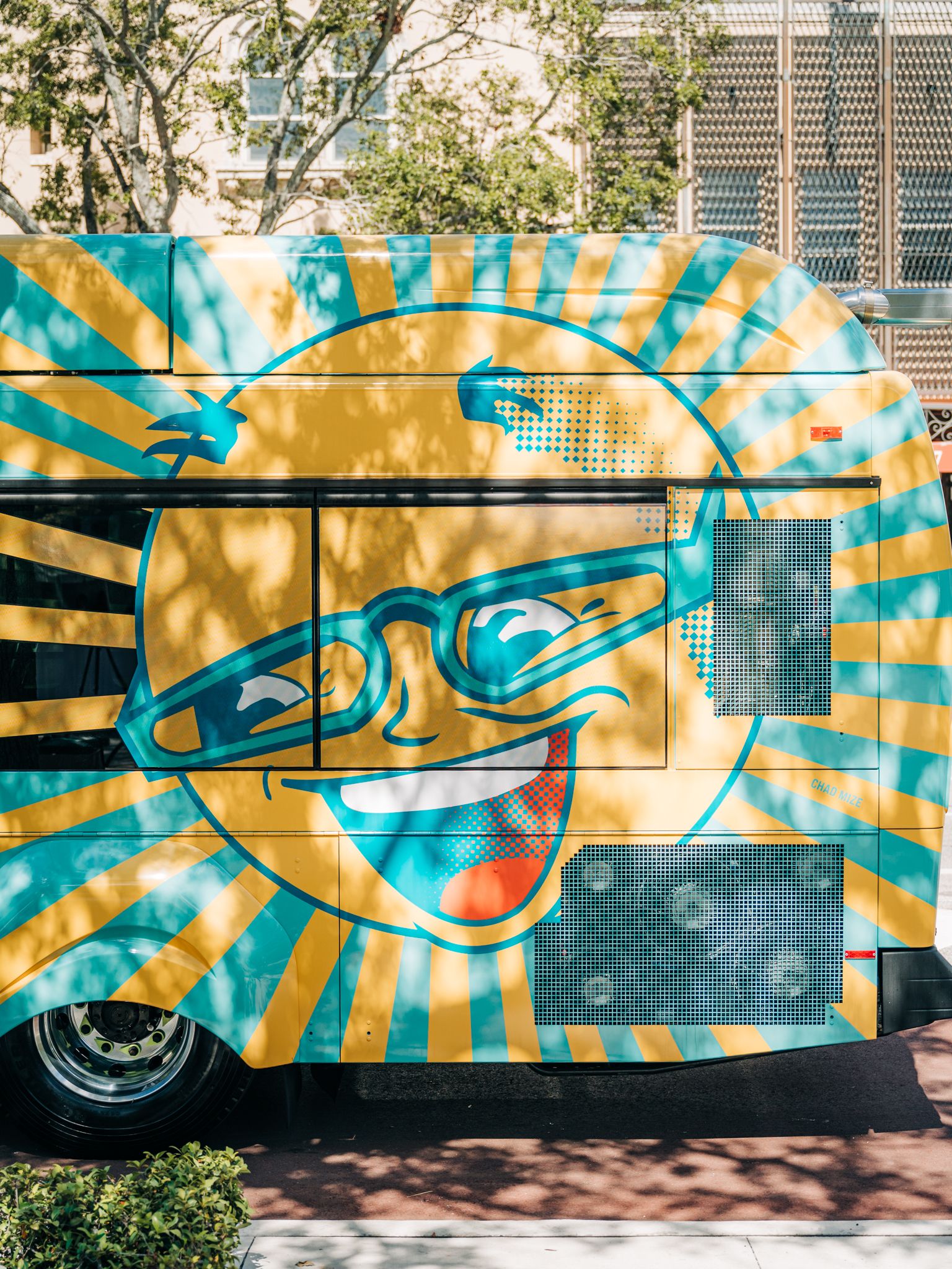 A photo of the Mr. Sun design on a SunRunner bus in dappled sunlight.